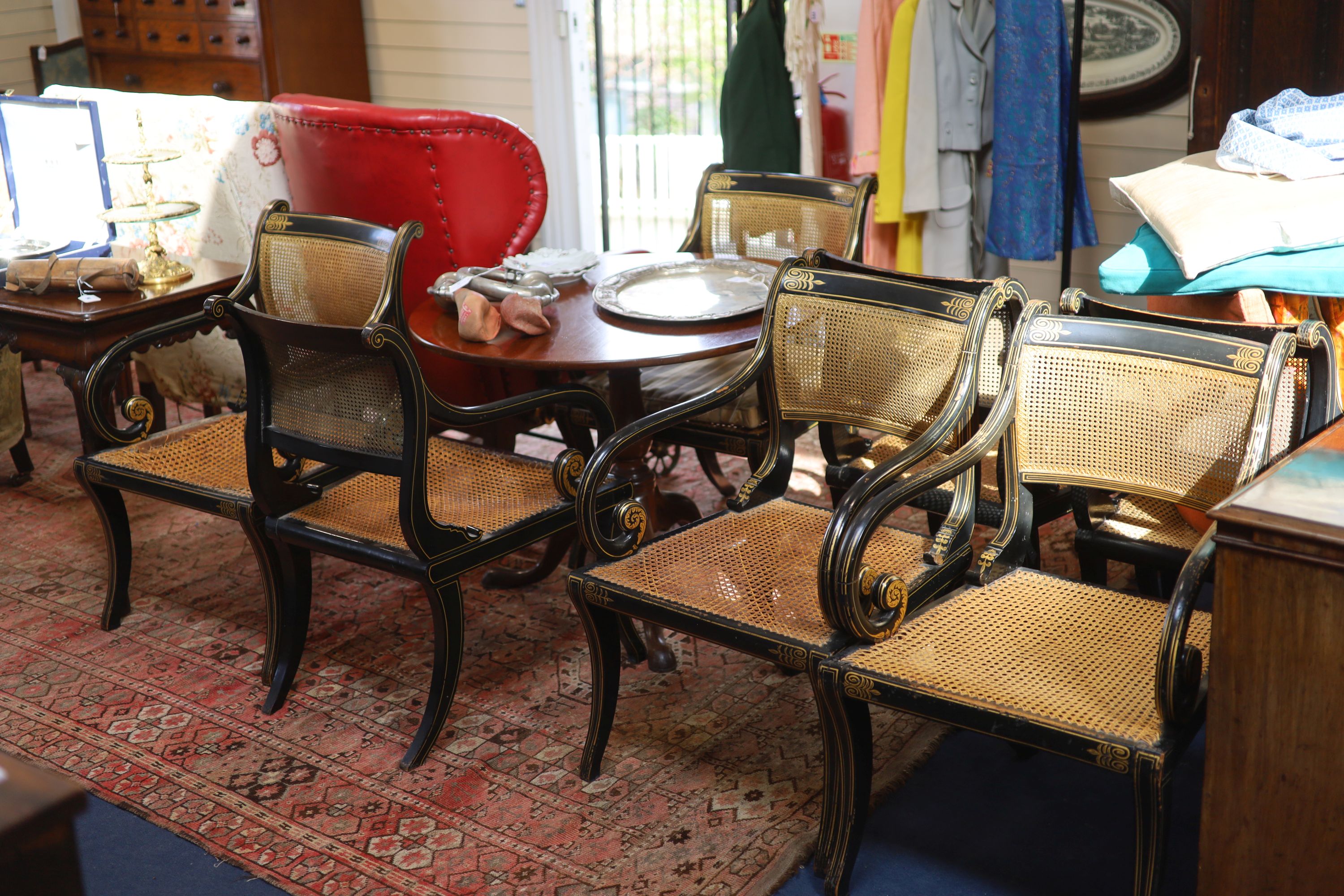 A set of seven Regency style parcel-gilt decorated ebonised armchairs, 19th century,